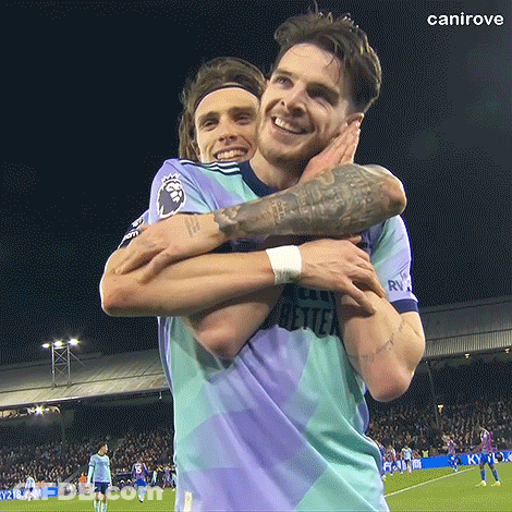 Two Men Are Hugging Each Other On A Soccer Field And One Has A Tattoo On His Arm GIF