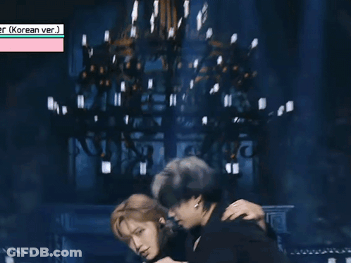 Two Men Are Hugging Each Other On A Stage . GIF