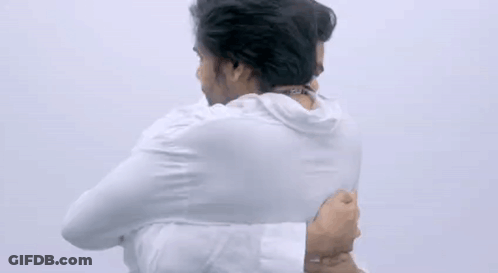 Two Men Are Hugging Each Other With Their Arms Around Each Other . GIF