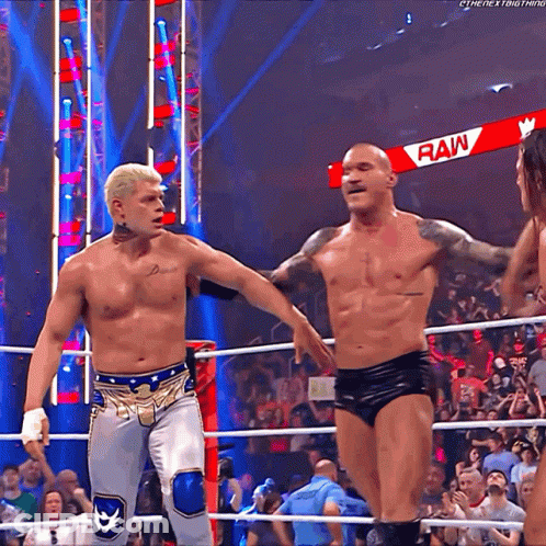 Two Men Are In A Wrestling Ring With A Sign That Says Raw GIF