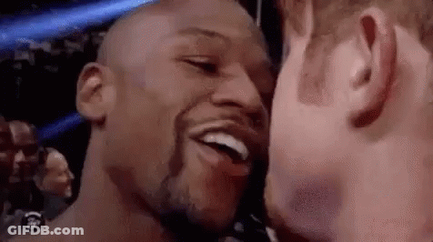 Two Men Are Kissing Each Other On The Cheek And Smiling . GIF