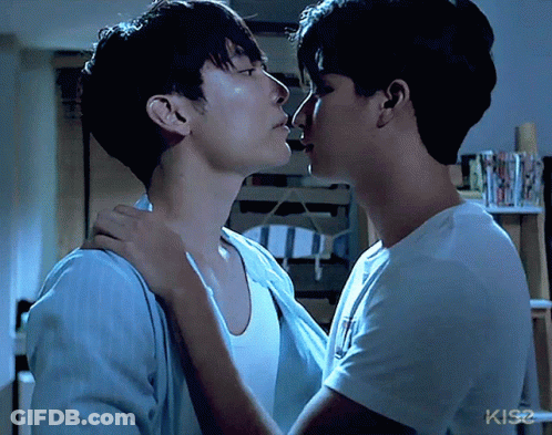 Two Men Kissing In Front Of KIS2 Sign GIF
