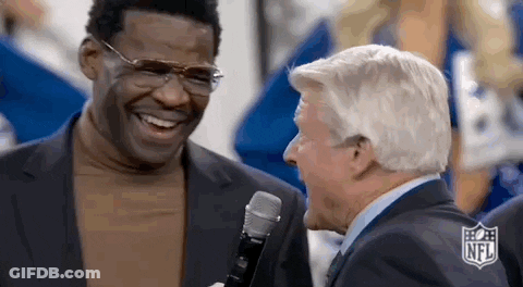 Two Men Are Laughing And Talking Into A Microphone While Standing Next To Each Other . GIF