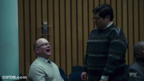 Two Men Are Laughing In Front Of A Wall With Fx On It GIF
