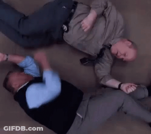 Two Men Are Laying On The Floor Fighting . GIF