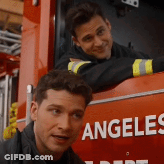 Two Men Are Leaning On The Side Of A Fire Truck That Says Angeles GIF