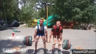 Two Men Are Lifting A Barbell In A Park With Makeagif.com At The Bottom GIF