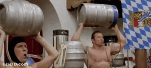 Two Men Are Lifting Kegs Over Their Heads In Front Of A Flag GIF