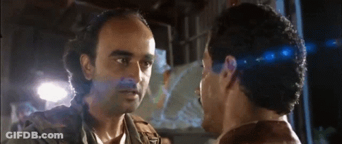 Two Men Are Looking At Each Other And One Has A Beard GIF