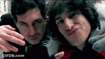 Two Men Are Making Funny Faces For The Camera While Standing Next To Each Other . GIF