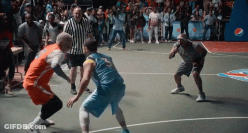 Two Men Are Playing A Game Of Basketball On A Court With A Crowd Watching . GIF