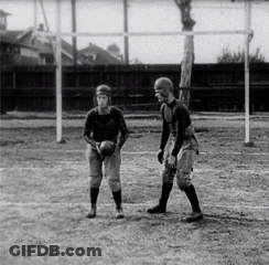 Two Men Are Playing A Game Of Football On A Field In A Black And White Photo . GIF