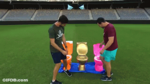 Two Men Are Playing A Game Of Toilets On A Field With The Words How Ridiculous Below Them GIF