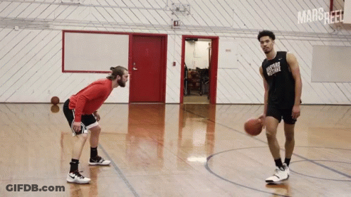 Two Men Are Playing Basketball In A Gym And One Has A Shirt That Says Oxford College GIF