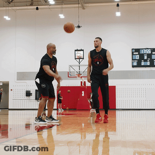 Two Men Are Playing Basketball In A Gym And One Of Them Is Wearing A Bulls Shirt GIF