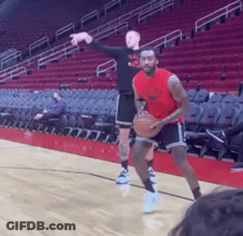 Two Men Are Playing Basketball In A Stadium With Empty Seats GIF