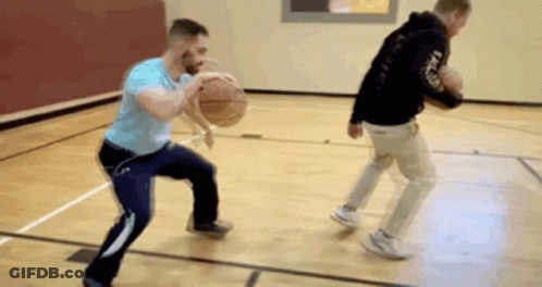 Two Men Are Playing Basketball On A Court And One Is Dribbling The Ball . GIF