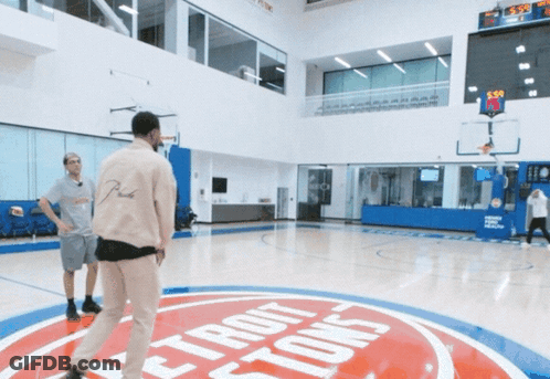 Two Men Are Playing Basketball On A Court With A Detroit Pistons Logo On The Floor GIF