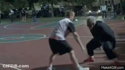 Two Men Are Playing Basketball On A Court With A Referee . GIF