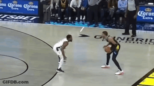 Two Men Are Playing Basketball On A Court With Corona Extra Advertisements On The Sidelines GIF