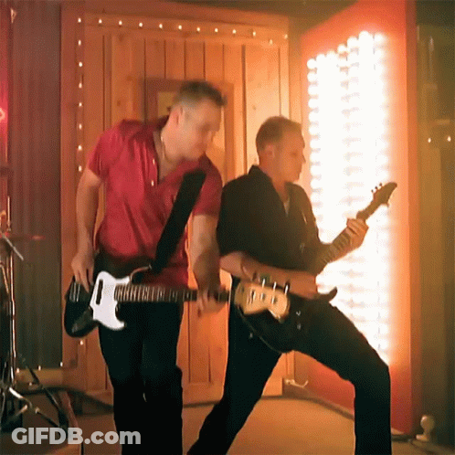 Two Men Are Playing Guitars In Front Of A Wall With Lights GIF