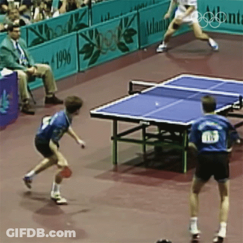Two Men Are Playing Ping Pong In Front Of A Sign That Says Atlanta GIF