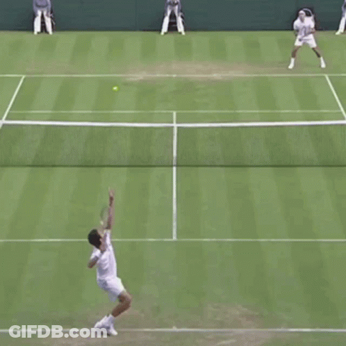 Two Men Are Playing Tennis On A Court And One Of Them Is Running Towards The Net GIF