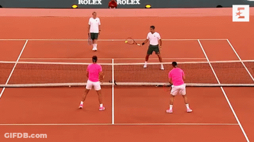 Two Men Are Playing Tennis On A Court With Rolex Advertisements On The Wall Behind Them GIF