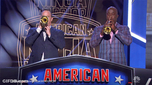Two Men Are Playing Trumpets In Front Of A Banner That Says American GIF