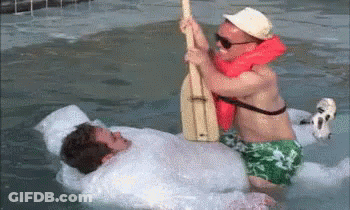 Two Men Are Playing With A Paddle In A Swimming Pool . GIF