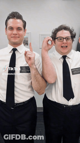 Two Men Are Posing For A Picture And One Has A Name Tag That Says Sammcstellar GIF