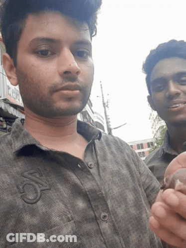 Two Men Are Posing For A Picture And One Has The Letter S On His Shirt GIF