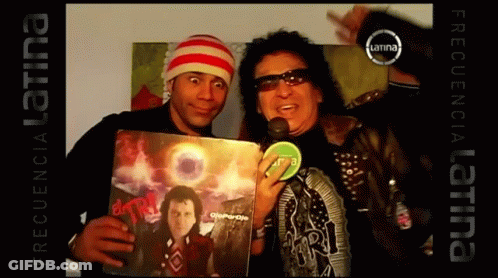 Two Men Are Posing For A Picture And One Of Them Is Holding A Record That Says ' Frequency Latina ' On The Bottom GIF