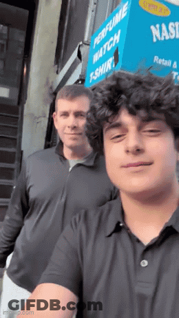 Two Men Are Posing For A Picture In Front Of A Perfume Watch T-Shirt Store GIF
