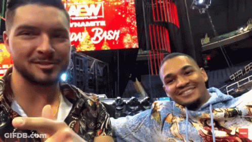 Two Men Are Posing For A Picture In Front Of A Sign That Says Aew Day Bash GIF