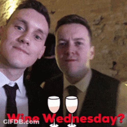 Two Men Are Posing For A Picture With The Words Wine Wednesday Behind Them GIF