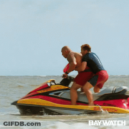 Two Men Are Riding A Jet Ski In The Ocean With The Word Baywatch On The Bottom . GIF