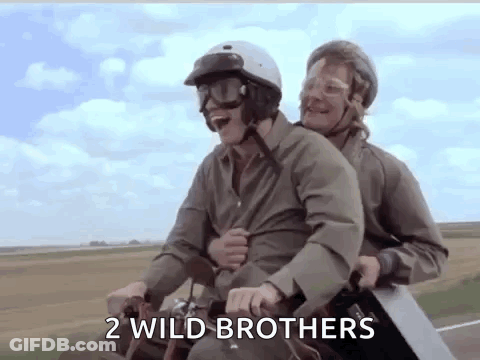Two Men Are Riding A Motorcycle With A Saw On Their Backs . GIF