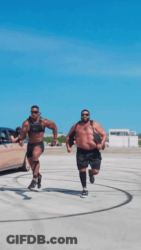 Two Men Are Running In A Parking Lot With One Wearing A Weighted Vest GIF