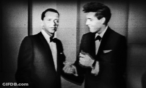Two Men Are Shaking Hands In A Black And White Photo . GIF