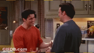 Two Men Are Shaking Hands In A Kitchen In A Friends Episode . GIF