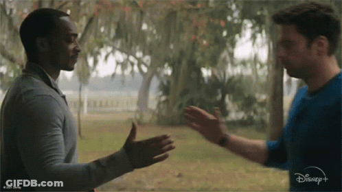 Two Men Are Shaking Hands In Front Of A Disney + Logo GIF