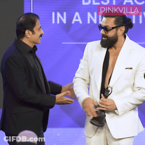 Two Men Are Shaking Hands In Front Of A Pinkvilla Logo GIF