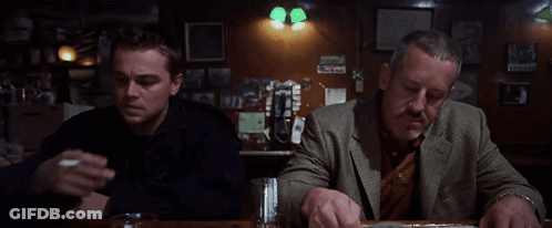 Two Men Are Sitting At A Bar Smoking Cigarettes And Drinking Beer GIF