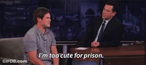 Two Men Are Sitting At A Table And One Of Them Is Saying I 'M Too Cute For Prison GIF