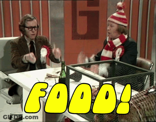 Two Men Are Sitting At A Table And The Word Food Is On The Screen GIF