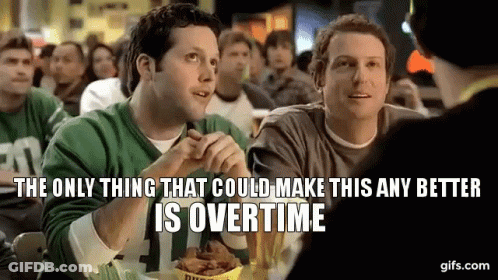 Two Men Are Sitting At A Table In A Restaurant Eating Chicken Wings . GIF