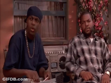 Two Men Are Sitting At A Table In Front Of A Boombox . GIF