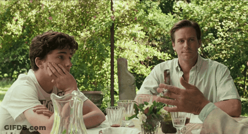 Two Men Are Sitting At A Table With A Pitcher Of Water GIF