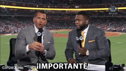 Two Men Are Sitting At A Table With Microphones In Front Of A Baseball Field And One Of Them Is Saying Importante GIF